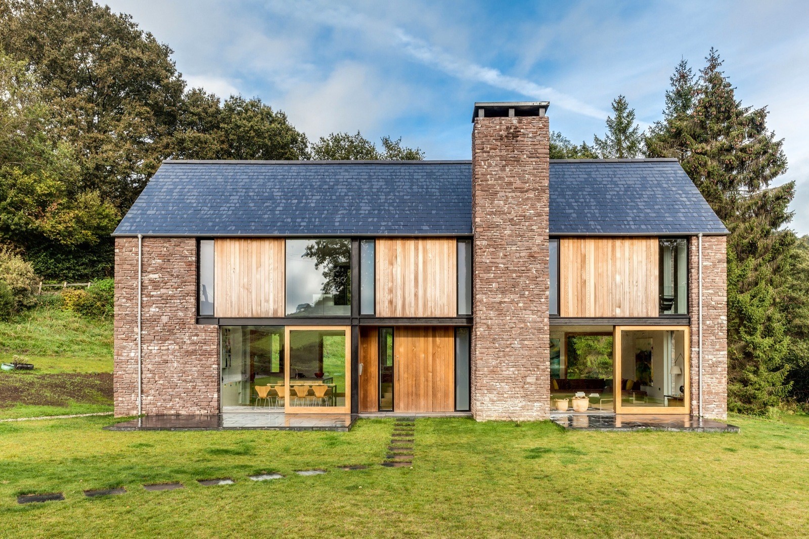 Дом в скандинавском стиле с широкими окнами и отделкой под натуральный камень